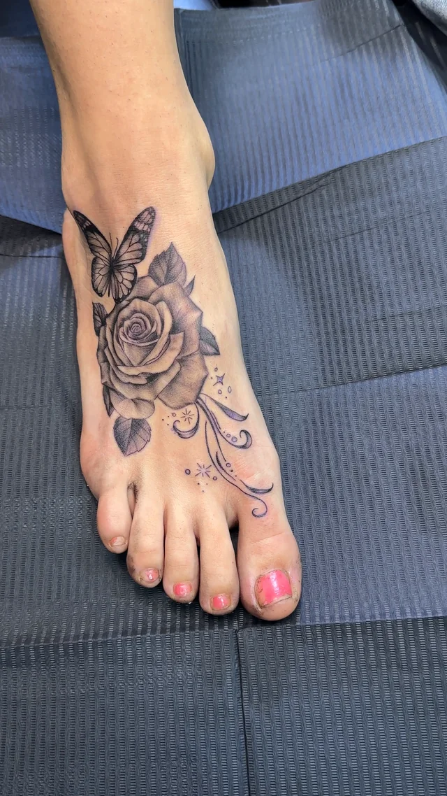 Rosa y mariposa en black & grey en el empeine