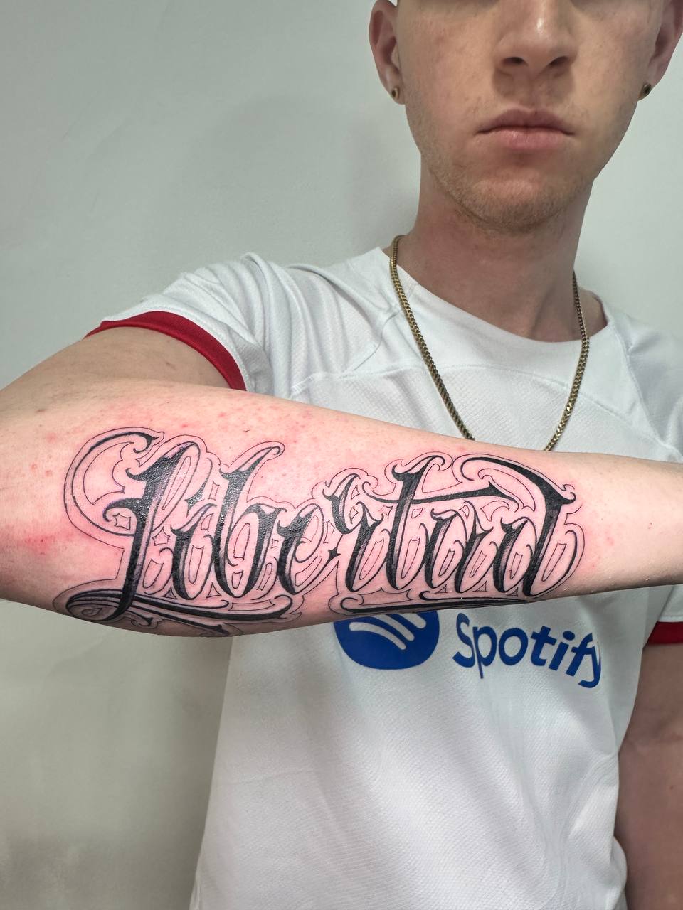 Lettering 'Libertad' en el antebrazo