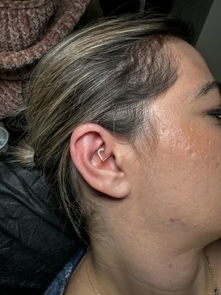 Piercing de oreja con joya en forma de corazón