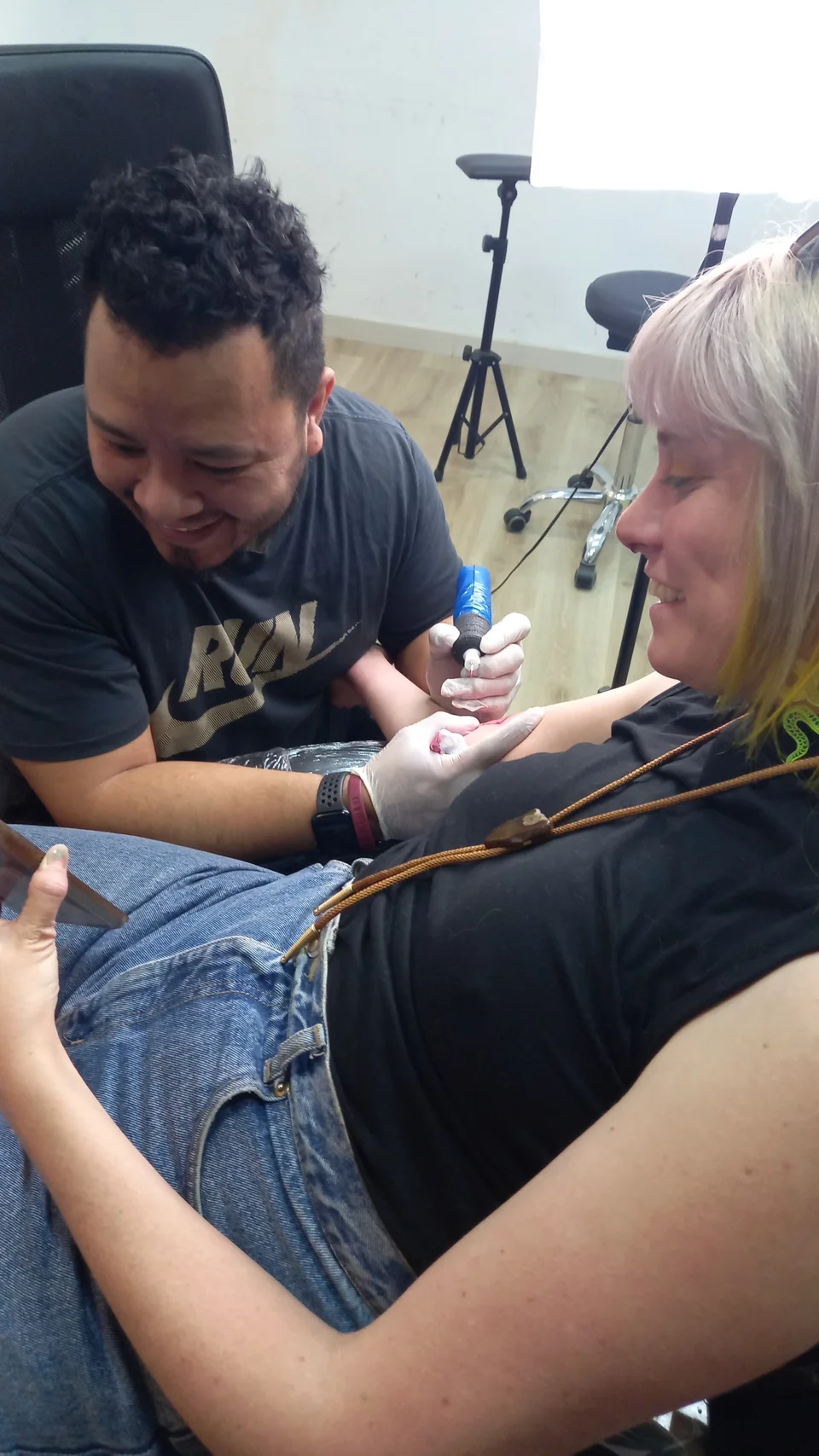 El artista tatuando a una clienta en el estudio