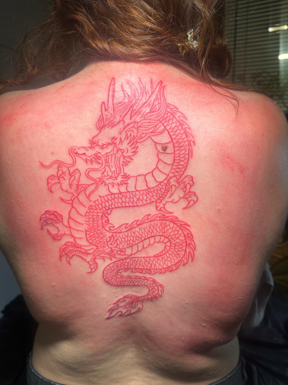 Dragón oriental en tinta roja — espalda