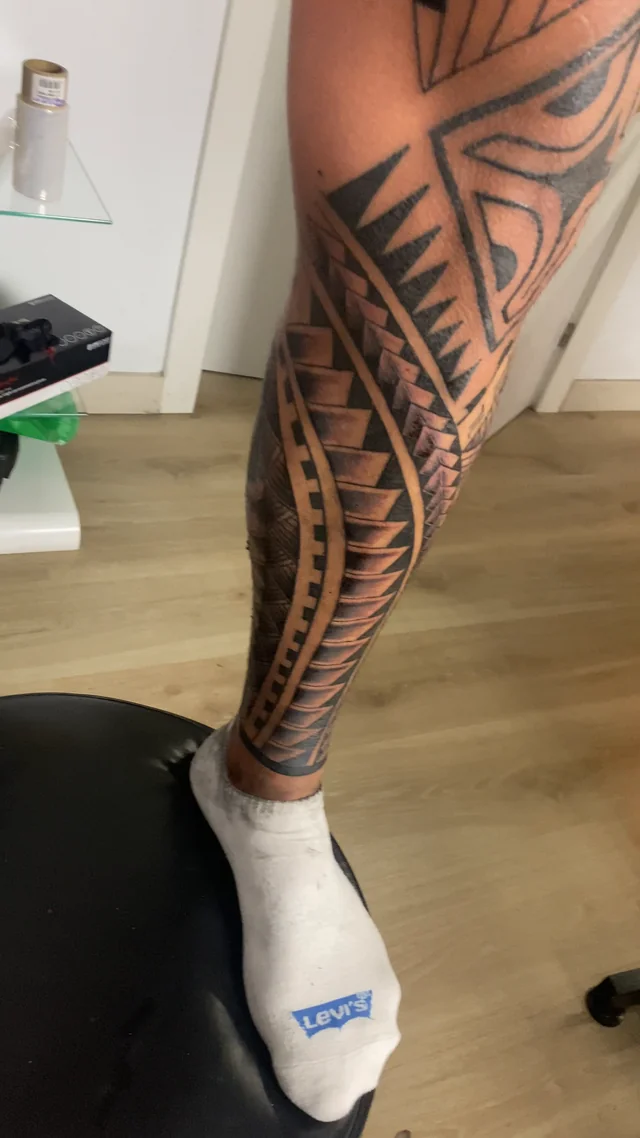 Tatuaje maorí alrededor de la pierna